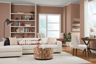 A living room with white furniture and walls painted light red-beige