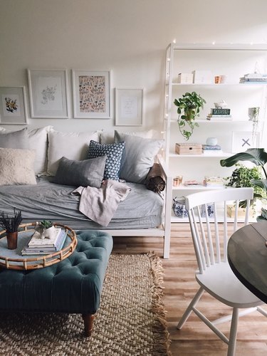 blue tufted ottoman in studio apartment living room
