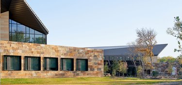 exterior of brick and glass building, and trees nearby