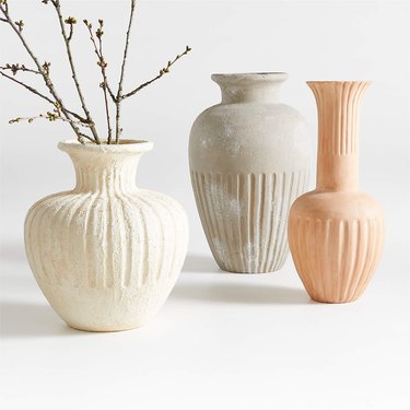 Three terracotta vases in different shapes: one white, one light orange, and one dusty beige.
