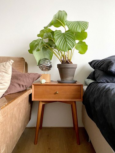 wood midcentury nightstand between bed and sofa