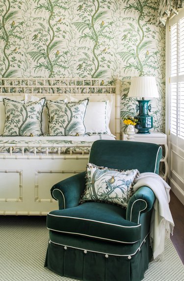 bedroom with ivory and emerald green chinoiserie wallpaper and emerald green chair