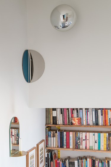 a hallway featuring books and curved mirrors