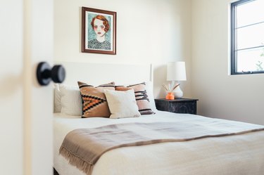 ivory bedroom with tan blanket and pillows