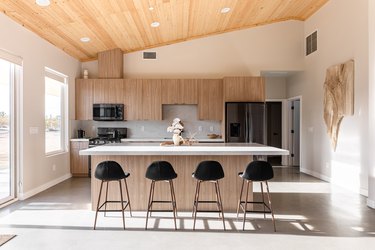 An open kitchen with oak cabinets and a wood ceiling