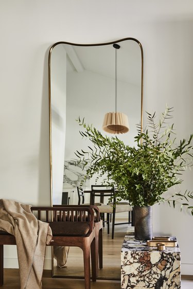 A Soho House mirror leans against the wall in the entry.