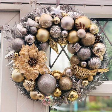 Silver and gold bauble wreath hanging on a door