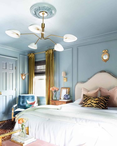 Glam bedroom with monochromatic blue paint and gold accents.