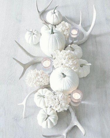 Spread with white pumpkins, faux antlers, and candles