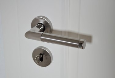 stainless steel door handle with a white door