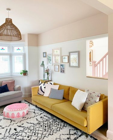 Eclectic living room with beige ceiling paint and yellow couch.