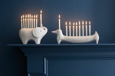 Jonathan Adler elephant and dachshund menorah with lit candles on a navy blue background