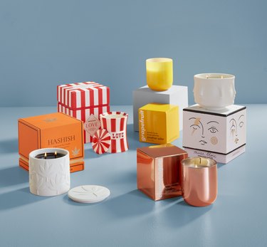 Jonathan Adler fall candle collection on a baby blue background