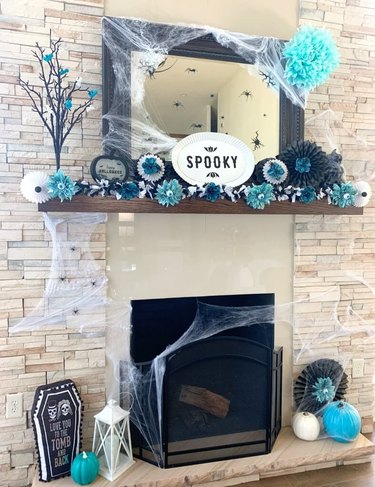 mantel with teal, black, and white halloween color scheme