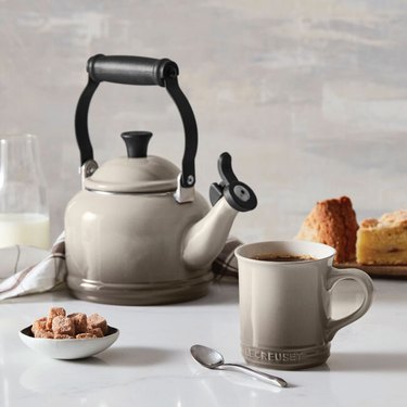 Le Creuset teapot and one mug on a counter
