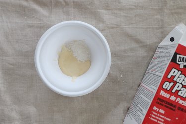 Plaster of Paris added to ivory paint in a disposable bowl