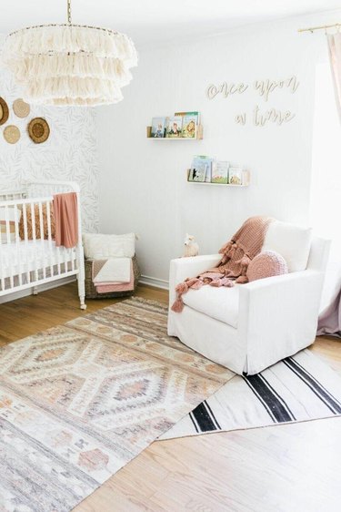 white nursery with layered rugs in different patterns