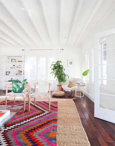 colorful patterned rug over natural fiber rug in living room