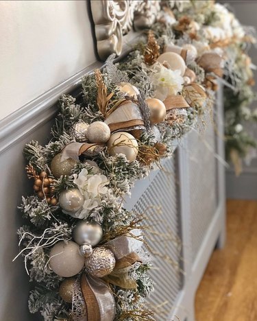 Silver and white festive garland on top of a radiator cover