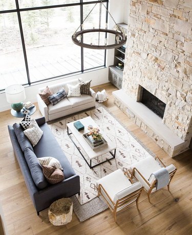 graphic patterned area rug on top of neutral area rug in great room