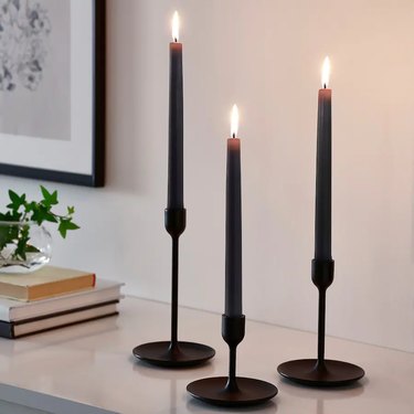 three black candlesticks in black candlestick holders