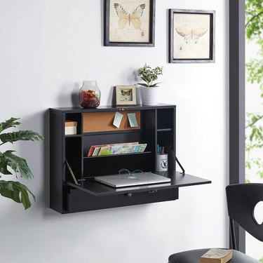 black wall-mounted folding desk on white wall