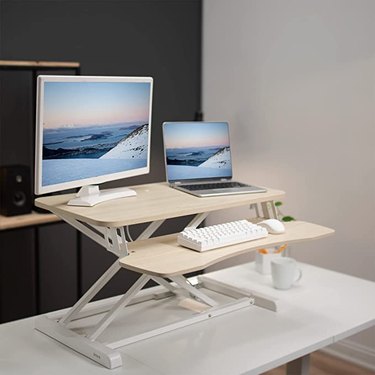 light wood and white metal standing desk converter with two tiers