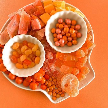 large plate and smaller plates on top with orange candy