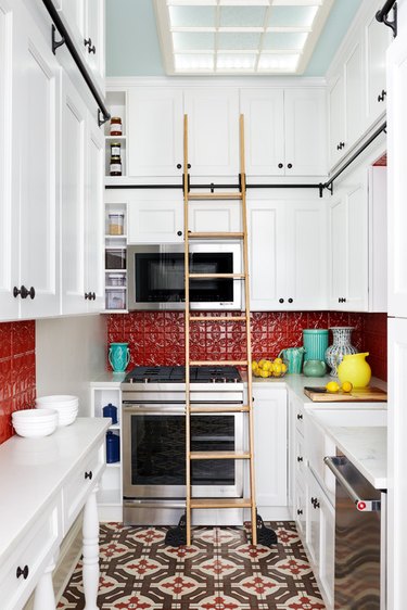 Red backsplash with white kitchen cabinets