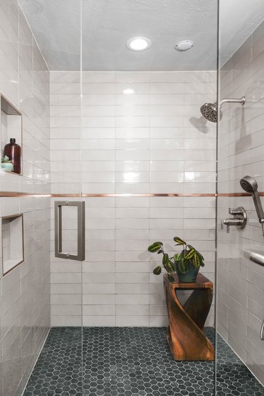White minimalist walk-in shower with copper trim