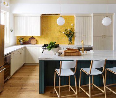 Yellow backsplash with white kitchen cabinets