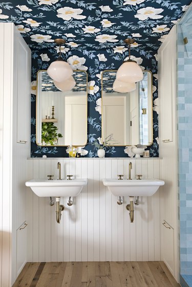 cottage bathroom with flowered wallpaper and integrated storage