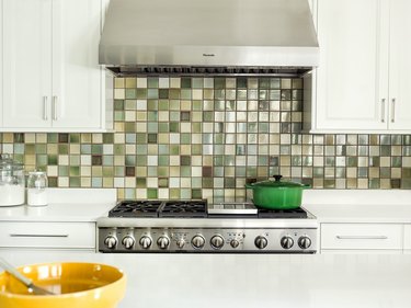 Olive green backsplash with white kitchen cabinets
