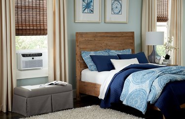 White window air conditioner in blue and beige bedroom
