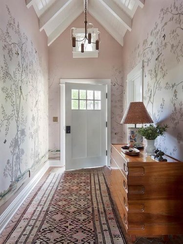 entryway with vaulted ceiling and pink walls