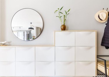 A white IKEA Trones shoe cabinet framed in light wood.