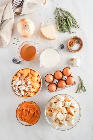 All of the ingredients laid out on a white marble countertop with a beige and blue and white striped tea towel.