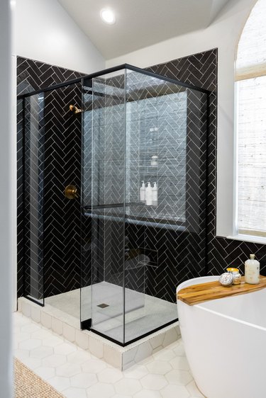 walk-in shower with black subway tile
