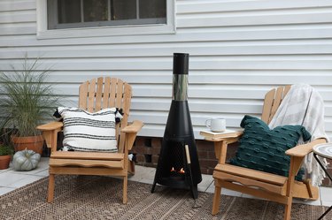 Two Adirondack chairs with outdoor fireplace in middle