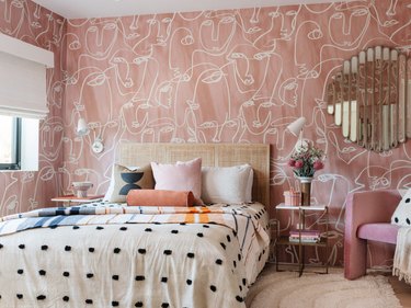 bedroom with pink wallpaper and black and white bedding