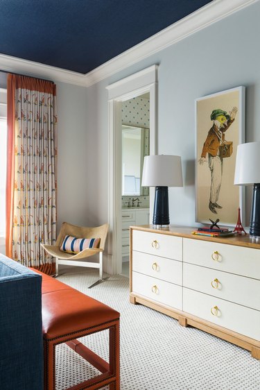 A child's bedroom in an orange, blue, wood and white color palette