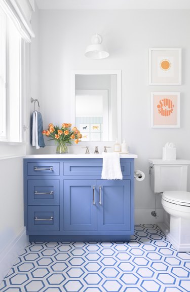 Bathroom with light blue vanity, blue tiled floor.
