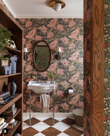 Bathroom with floral wallpaper, brown and white floors.