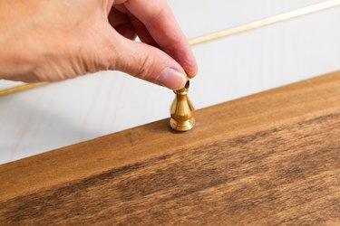 Adding brass hardware to shelf