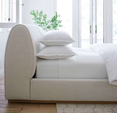 curved white bed frame and headboard