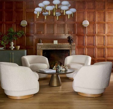 four ivory swivel chairs in a wood-paneled room