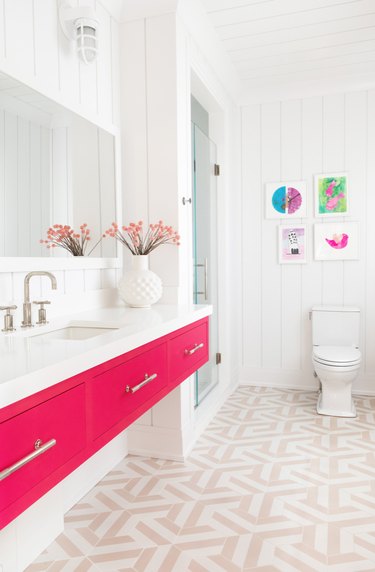 Bathroom with hot pink vanity, light rose colored tile floors.
