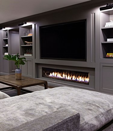 Basement with a TV and fireplace