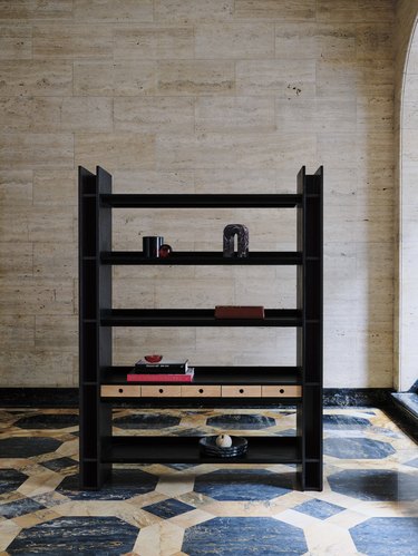 A black oak bookcase that features a thin line of horizontal drawers on the second shelf.