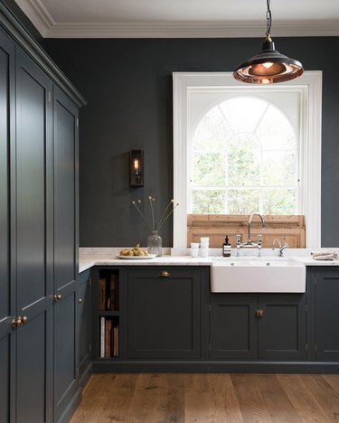 dark blue kitchen with arched window and wooden sliding shutters